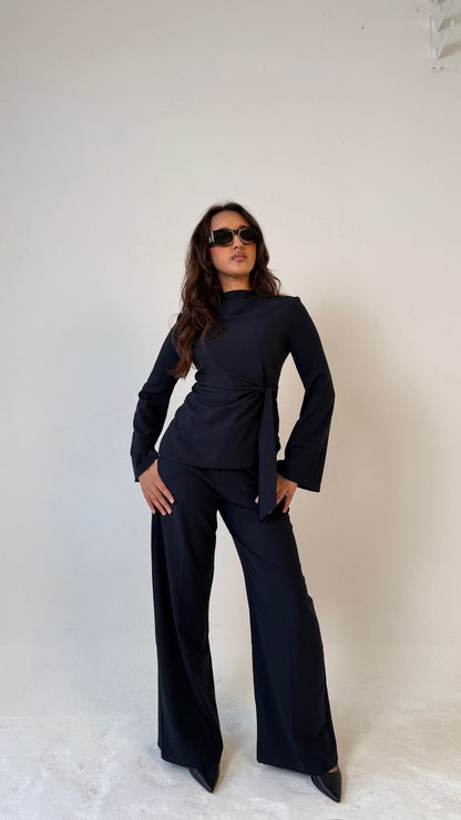 Model facing forward posing with hands on hips wearing Muse straight leg trousers in midnight blue, tailored fit for petite frames