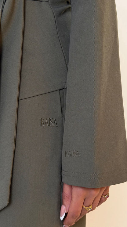 Close-up of KAISA logo detail on Muse straight leg trousers in olive green, petite tailored fit