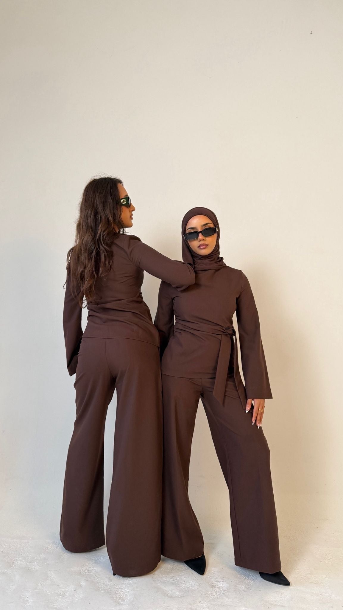 Two models, one facing forwards and one facing backwards, wearing Muse tailored tops in coffee brown, designed for petite frames with structured fit