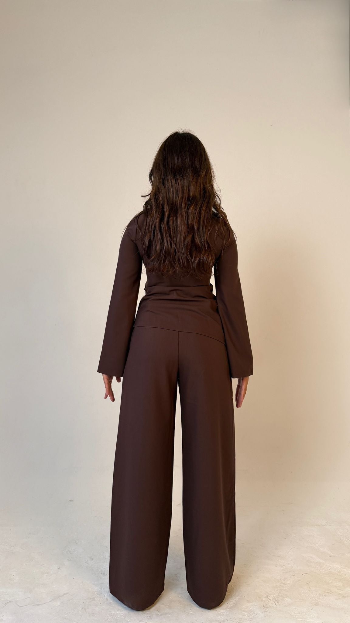Model facing away showing back view of Muse tailored top in coffee brown, designed for petite frames with structured fit