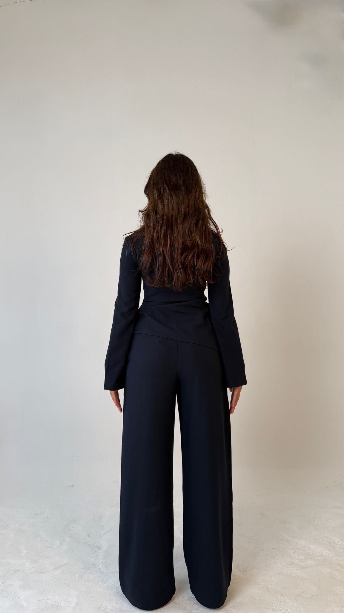 Model facing away showing back view of Muse tailored top in midnight blue, designed for petite frames with structured fit
