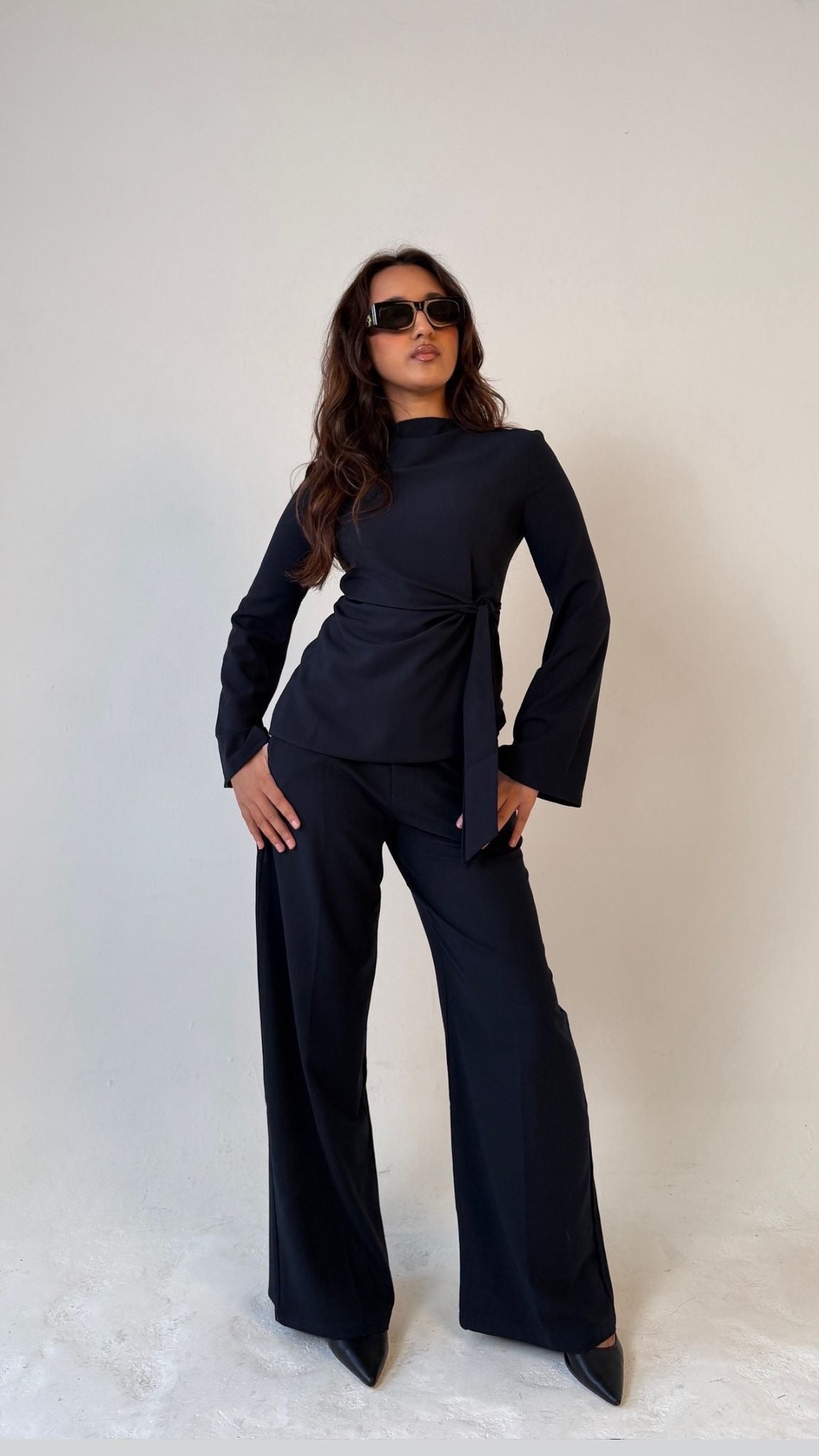 Model facing forward posing with hands on hips wearing Muse tailored top in midnight blue, designed for petite frames with structured fit