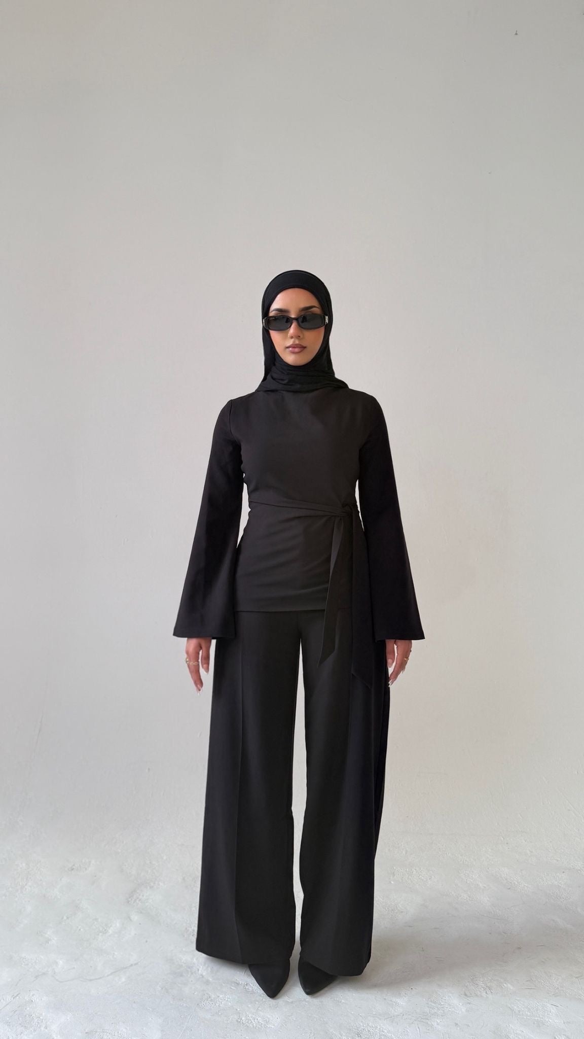Model facing forward wearing Muse tailored top in noir black, designed for petite frames with structured fit