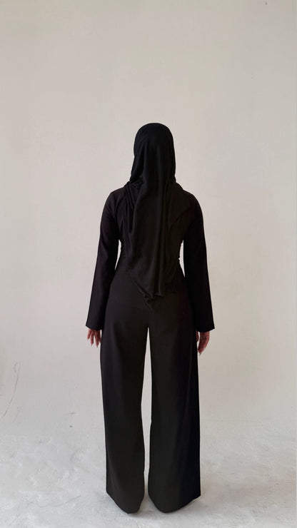 Model facing away showing back view of Muse tailored top in noir black, designed for petite frames with structured fit